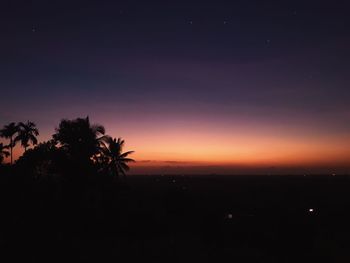 Silhouette trees against sky at sunset