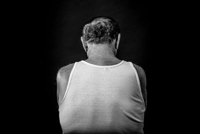 Rear view of man against black background