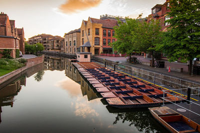 Canal amidst buildings in city against sky