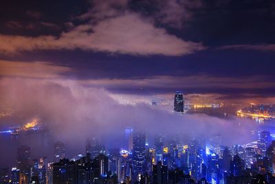 Aerial view of illuminated city against sky at sunset