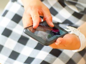 Midsection of woman using mobile phone