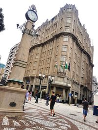 People walking on street amidst buildings in city