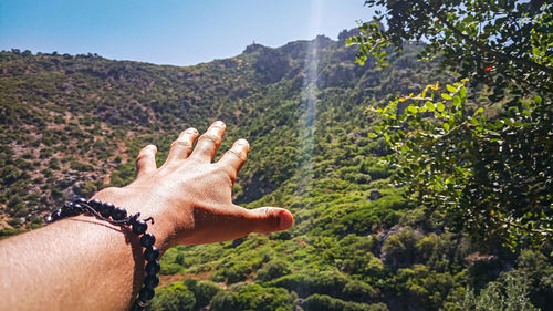 Midsection of person on mountain against sky