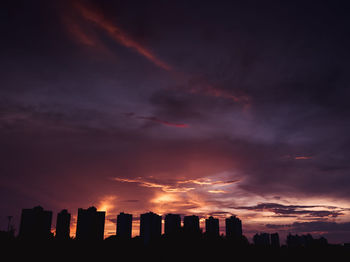 View of city against cloudy sky during sunset