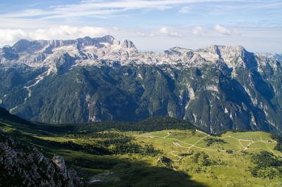 Scenic view of kanin mountain ridge against cloudy blue sky with malga pecol