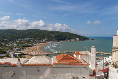 High angle view of buildings by sea against sky