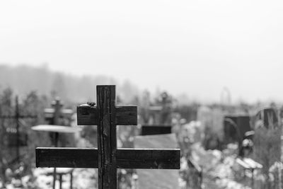 Cross on cemetery against sky