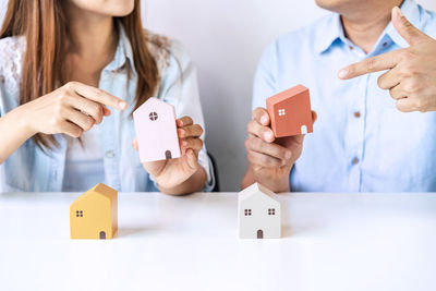 Midsection of couple holding toy on table