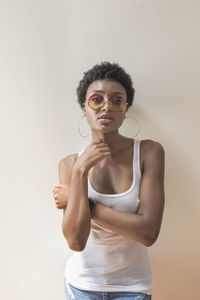 Portrait of young woman standing against white background