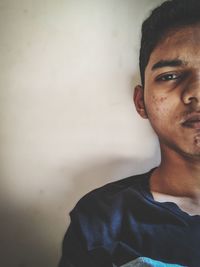 Portrait of young man against wall at home