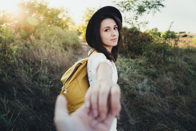 Portrait of beautiful young woman standing on field