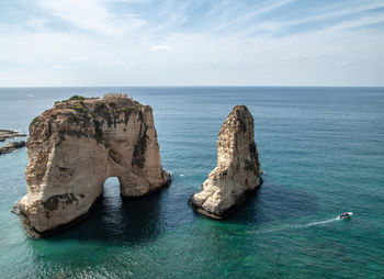 Rock formation in sea against sky