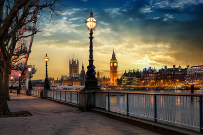 Big ben by thames river during sunset