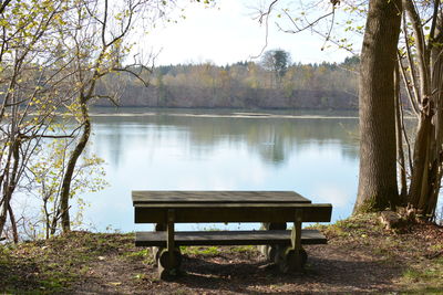 Empty bench by lake in park