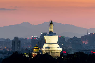 Buildings in city at sunset