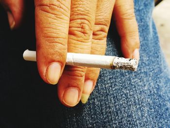 Cropped hand smoking cigarette