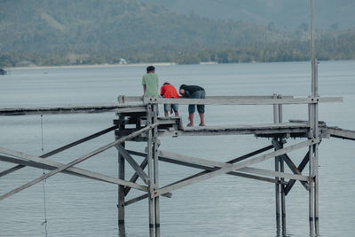 Rear view of people on lake against sky