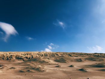 Scenic view of desert against blue sky