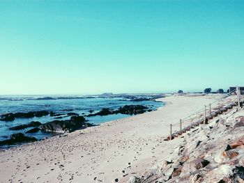 Scenic view of beach against clear blue sky