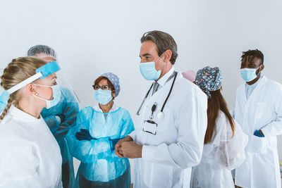 Doctors wearing mask standing against white background