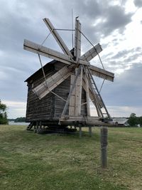 Traditional windmill on field against sky