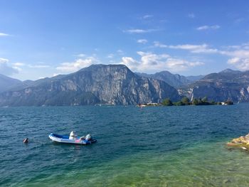 Scenic view of sea and mountains against sky