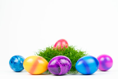 Close-up of multi colored eggs against white background