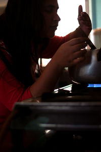 Side view portrait of woman holding smart phone