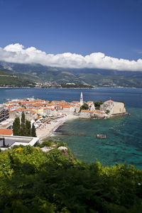 High angle view of townscape by sea against sky