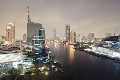 Aerial view of illuminated buildings in city against sky