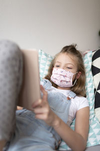 Girl using mobile phone on sofa at home