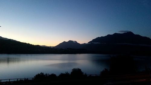 Scenic view of lake and mountains against clear sky