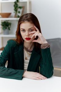 Portrait of young woman sitting on table