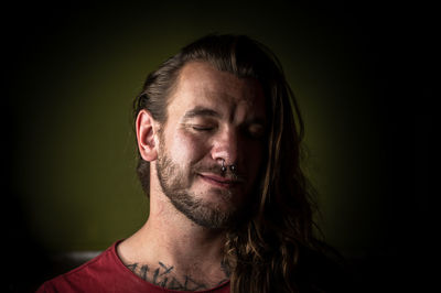 Close-up portrait of young man against black background