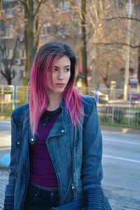 Beautiful young woman with arms raised in city