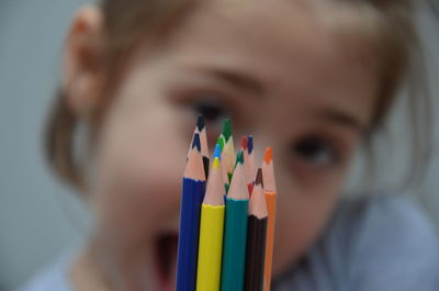 Portrait of girl showing colored pencils