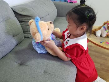 Cute boy sitting on sofa at home
