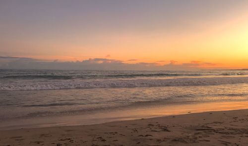 Scenic view of beach against sky during sunset