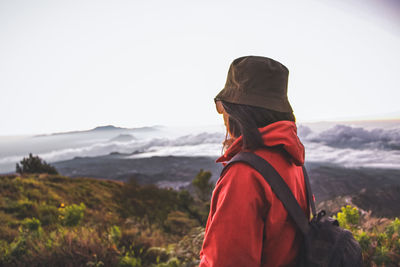 Man looking at mountain against sky