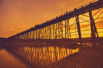 Bridge over river against sky during sunset