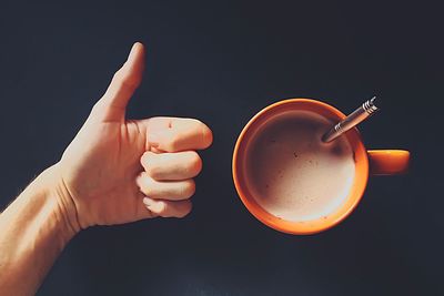 Mug of coffee and hand giving thumbs up