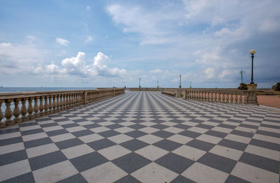 Street leading towards sea against sky