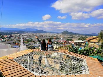 Rear view of friends sitting on observation point