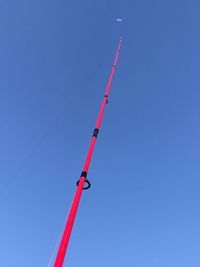 Low angle view of crane against clear blue sky