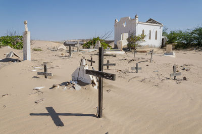 View of abandoned cemetery in desert against clear sky
