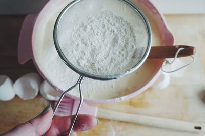 Cropped hand of woman preparing food at table