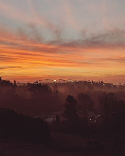 Scenic view of silhouette landscape against orange sky