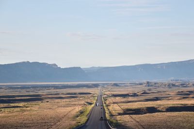 Road leading towards mountains against sky