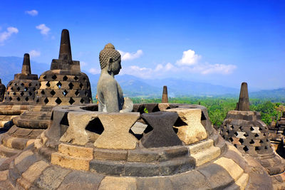 Statue of temple against cloudy sky