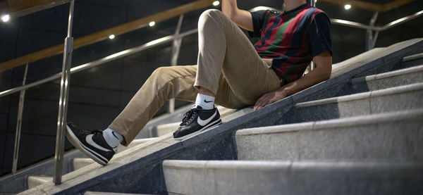 Low section of man sitting on staircase